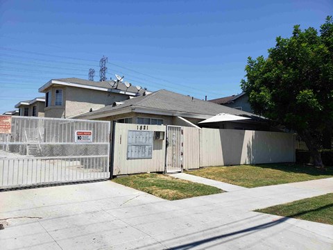 a house with a white fence and a yard in front of it