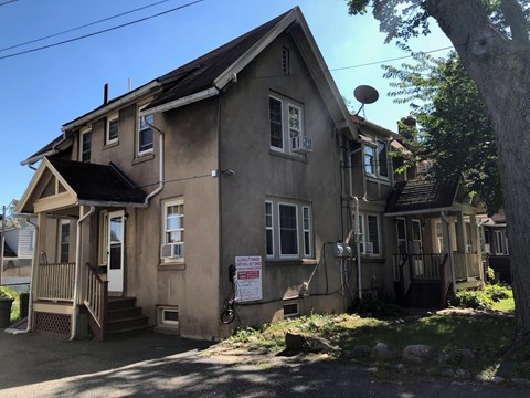 an old house with a sign in front of it