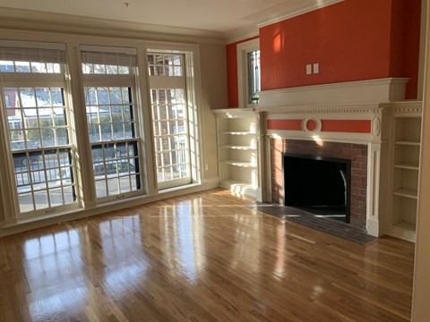 a living room with a fireplace and a hard wood floor