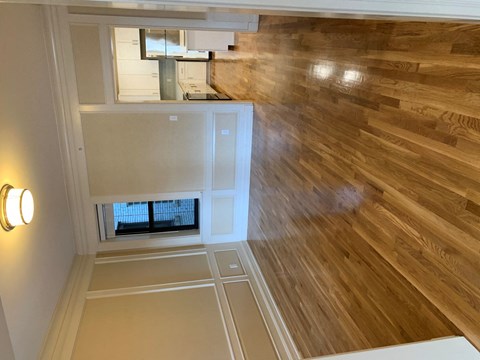 the view from the top of a staircase looking down into a room with wood floor
