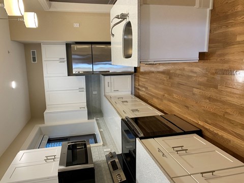 a kitchen with white cabinets and a wood floor