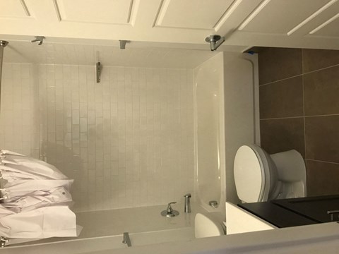 A bathroom with a toilet, sink, and shower.
