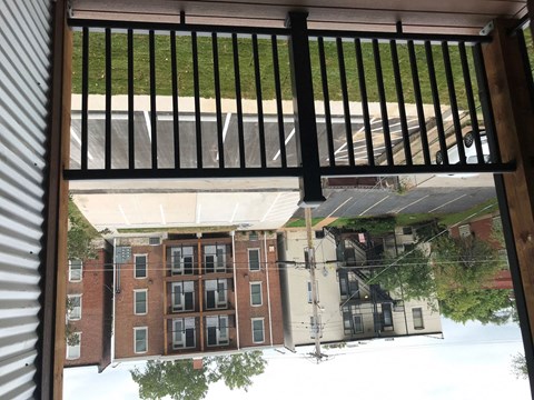 A view from a window looking out at a parking lot and a building.