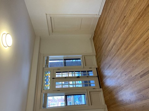 A wooden ceiling with a light on the left and a window in the middle.