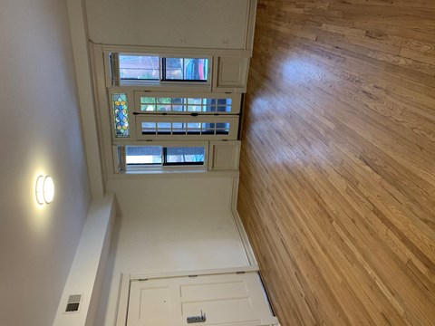 A wooden floor leads to a white door.
