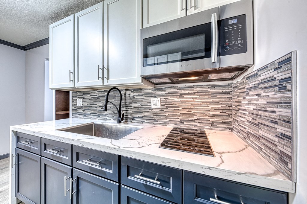 a kitchen with white cabinets and a sink and a microwave