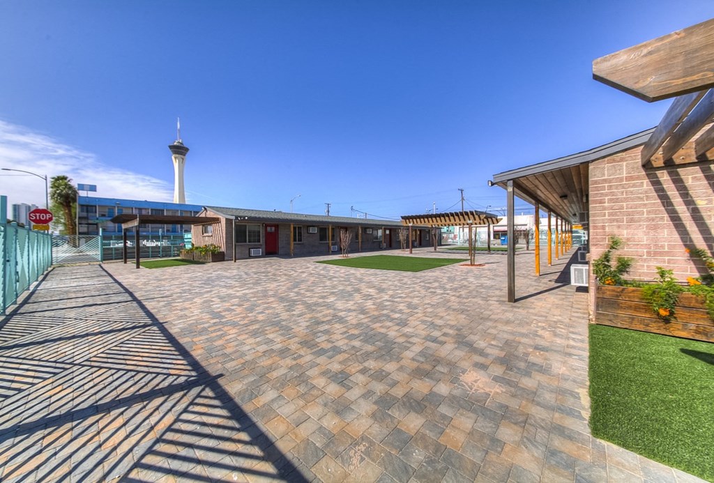 a courtyard with a building and a blue sky