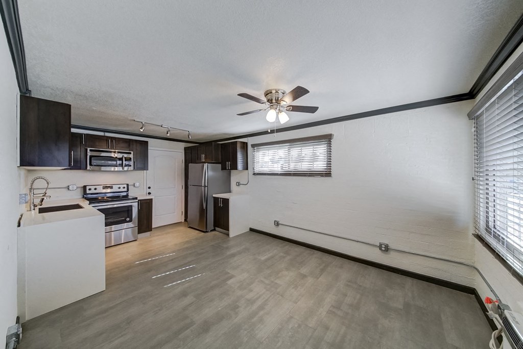 an empty kitchen with a ceiling fan and a sink
