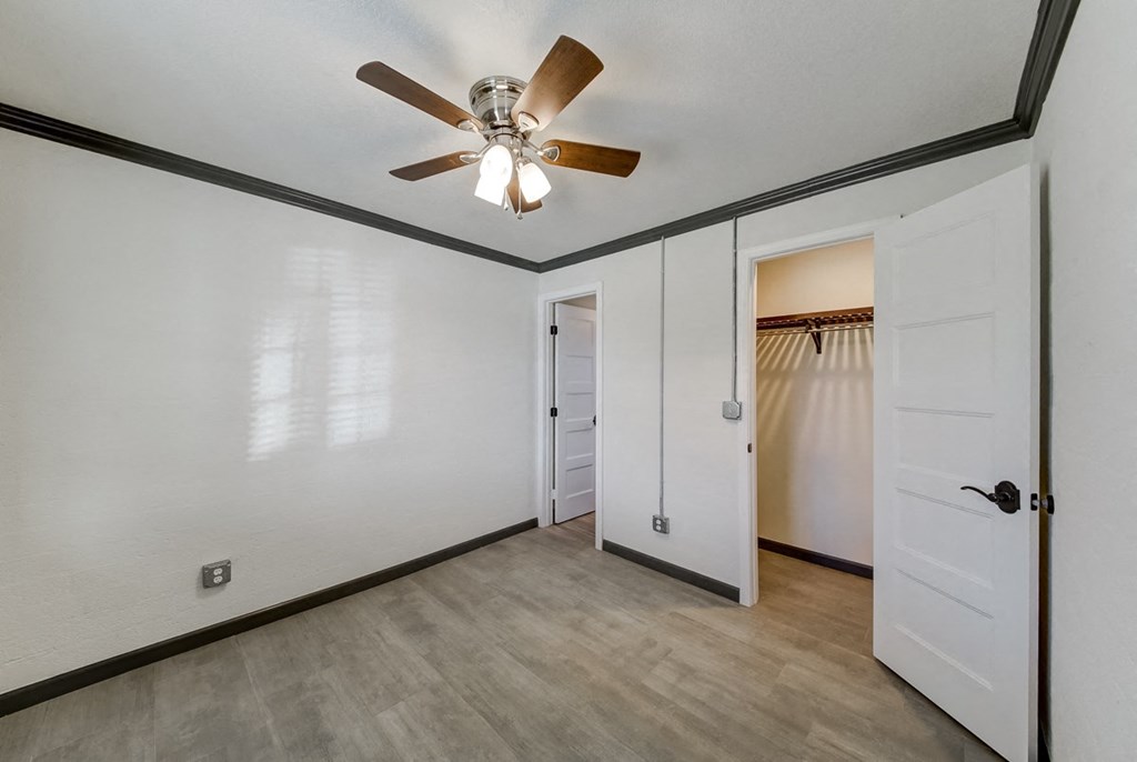 a bedroom with a ceiling fan and a door to a closet
