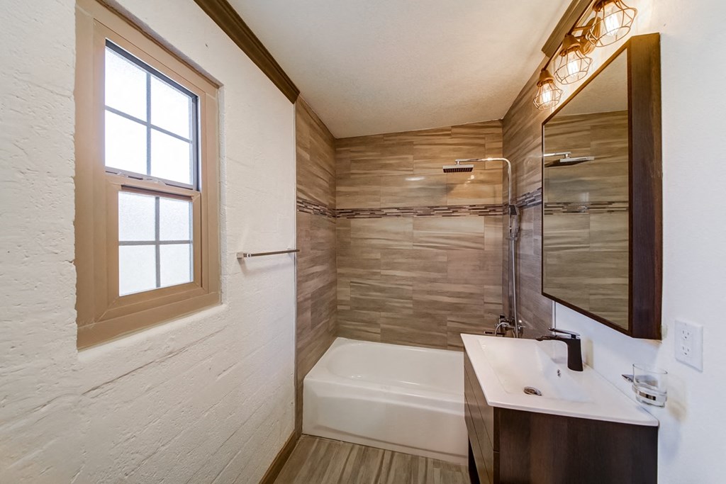 a bathroom with a tub and a sink and a window