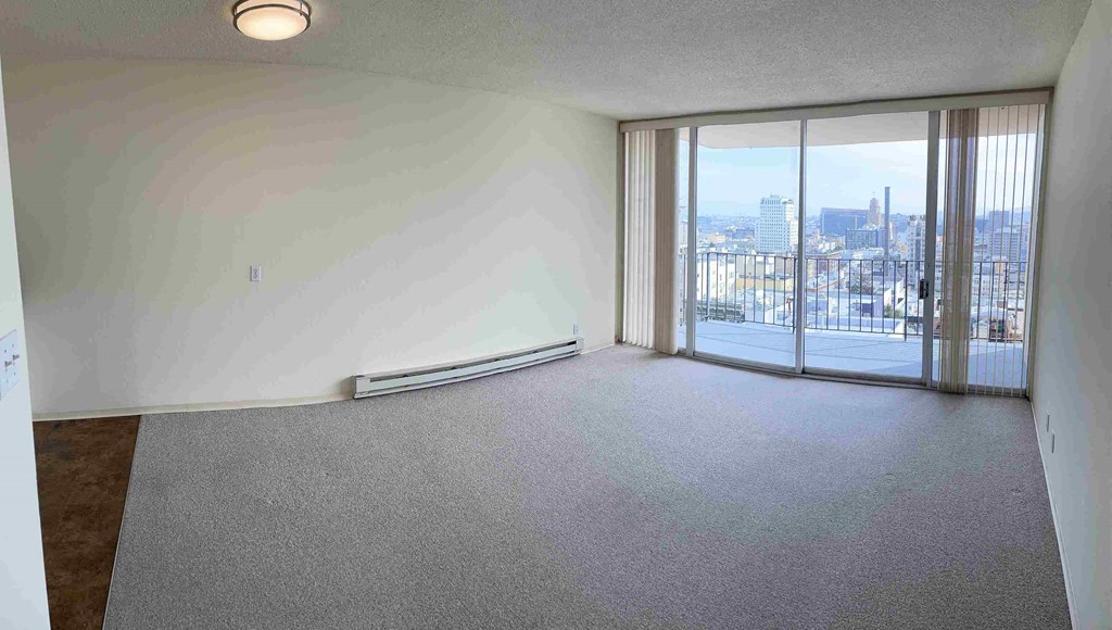 an empty living room with a view of the city