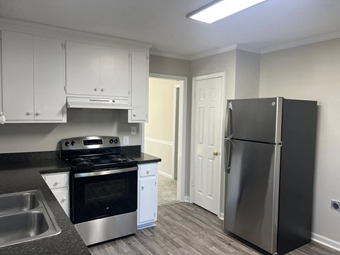A kitchen with a black refrigerator and stove.