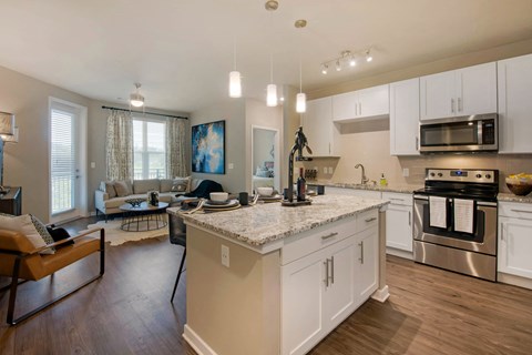 an open kitchen and living room with a large counter top