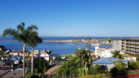 A view of a coastal town with buildings and a body of water.