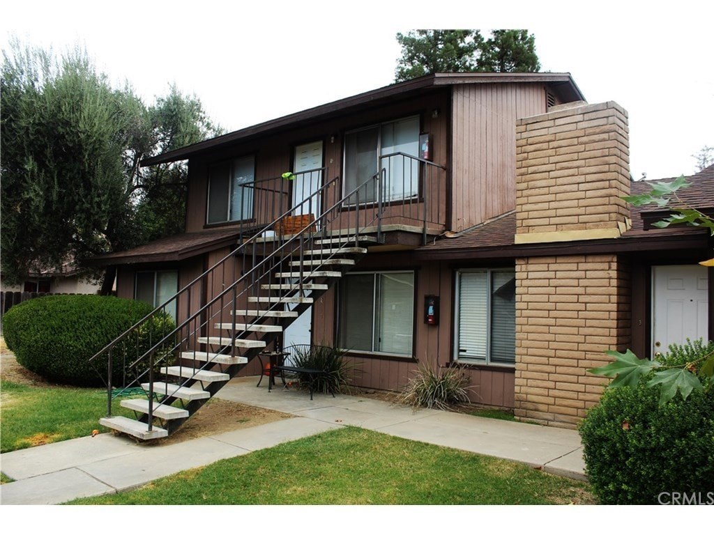 A brown house with a staircase leading to the second floor.