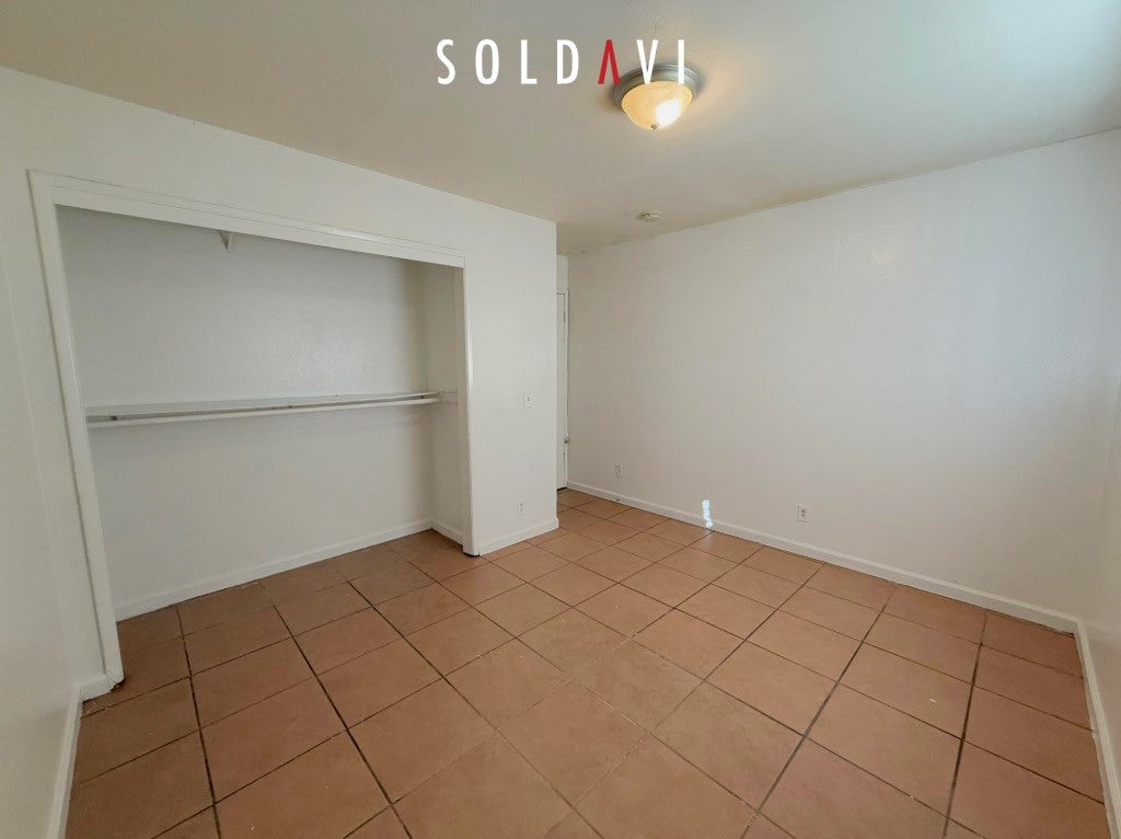 Empty room with tiled floor and white walls.