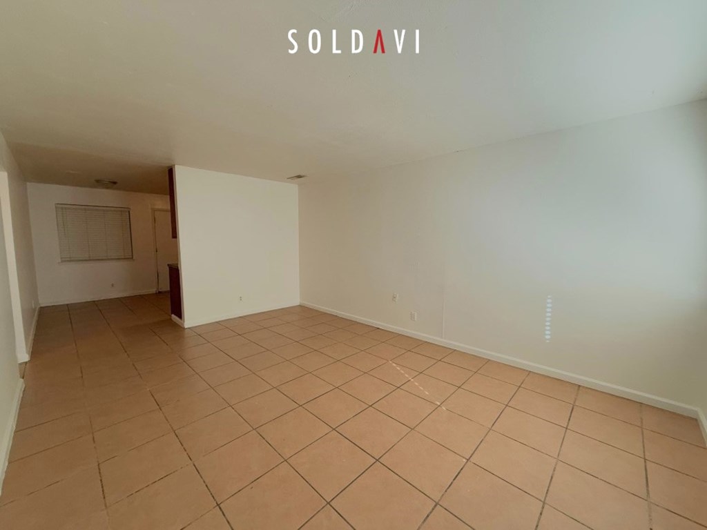 Empty room with tiled floor and white walls.