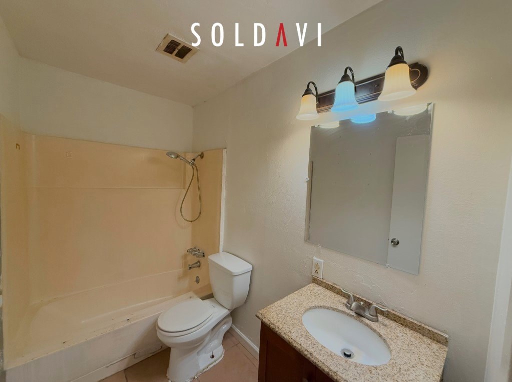 A bathroom with a toilet, sink, and mirror.