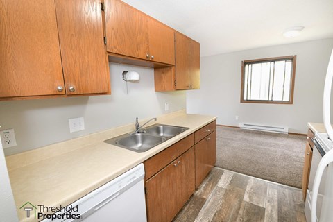 an empty kitchen with wooden cabinets and a sink