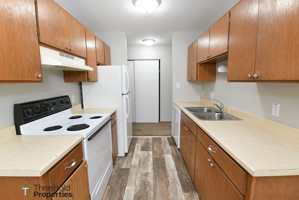 a kitchen with white appliances and wooden cabinets