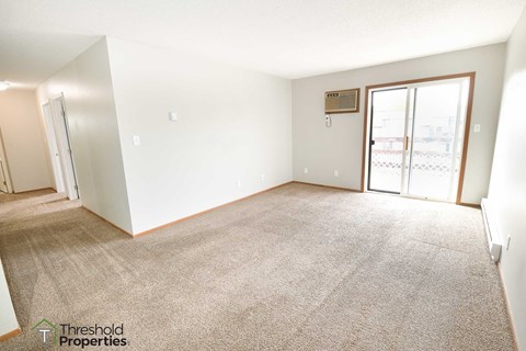 an empty living room with a door to a balcony
