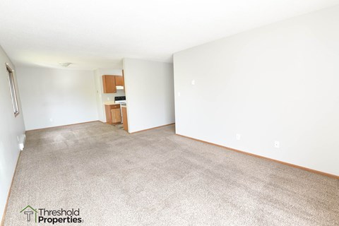 an empty living room with white walls and carpet