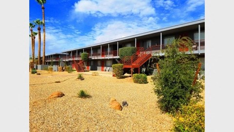 the courtyard of a motel with trees and plants