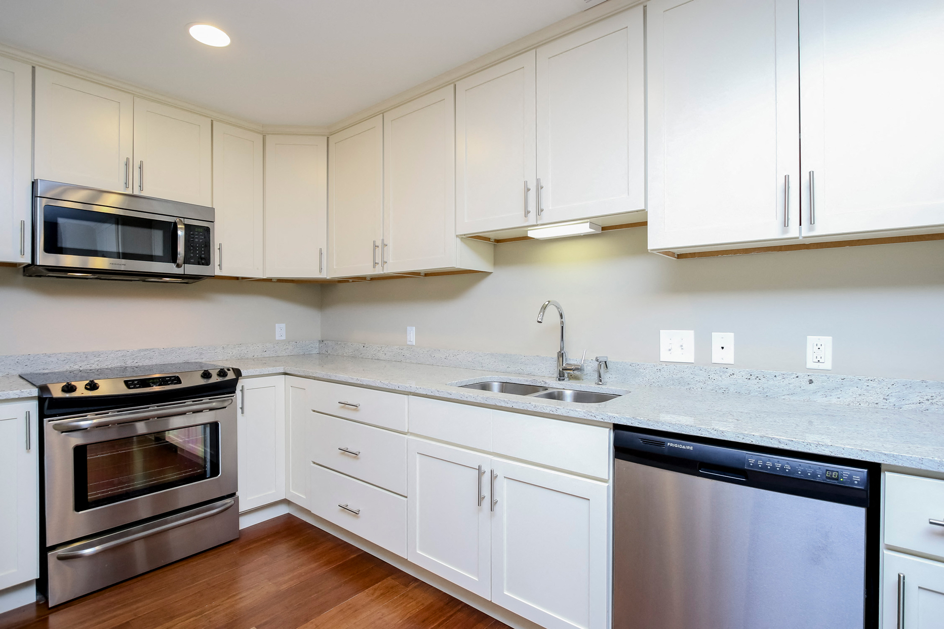 a kitchen with white cabinets and stainless steel appliances