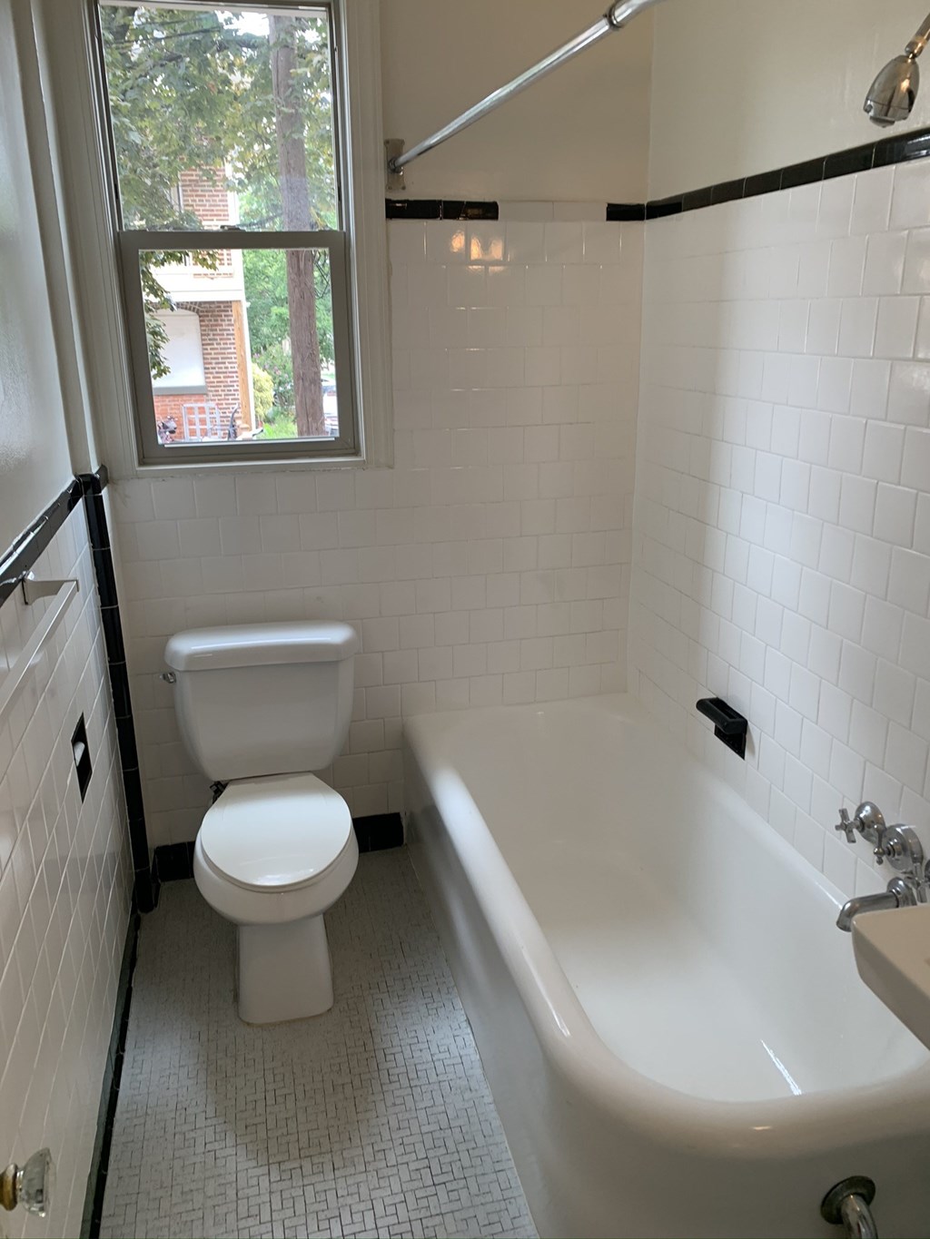 a bathroom with a toilet and a tub and a window