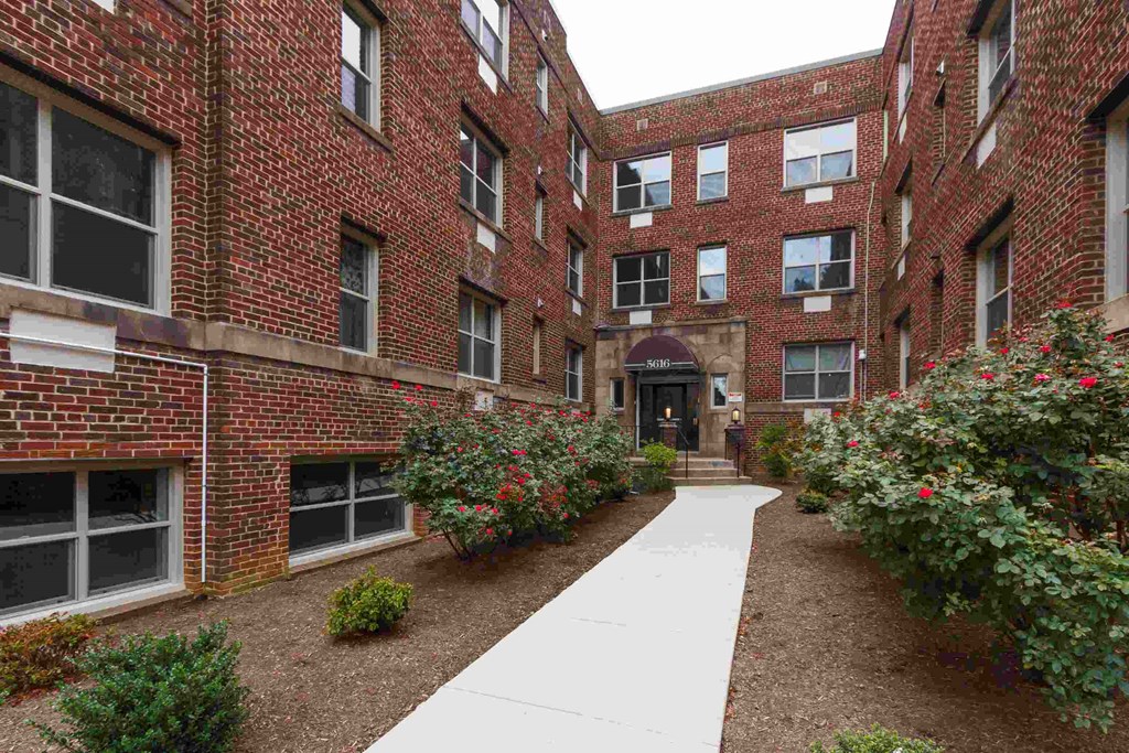 a walkway leading to the entrance of a red brick building