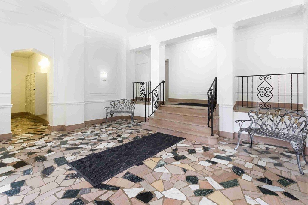 a living room with a staircase and a floor covered in tiles