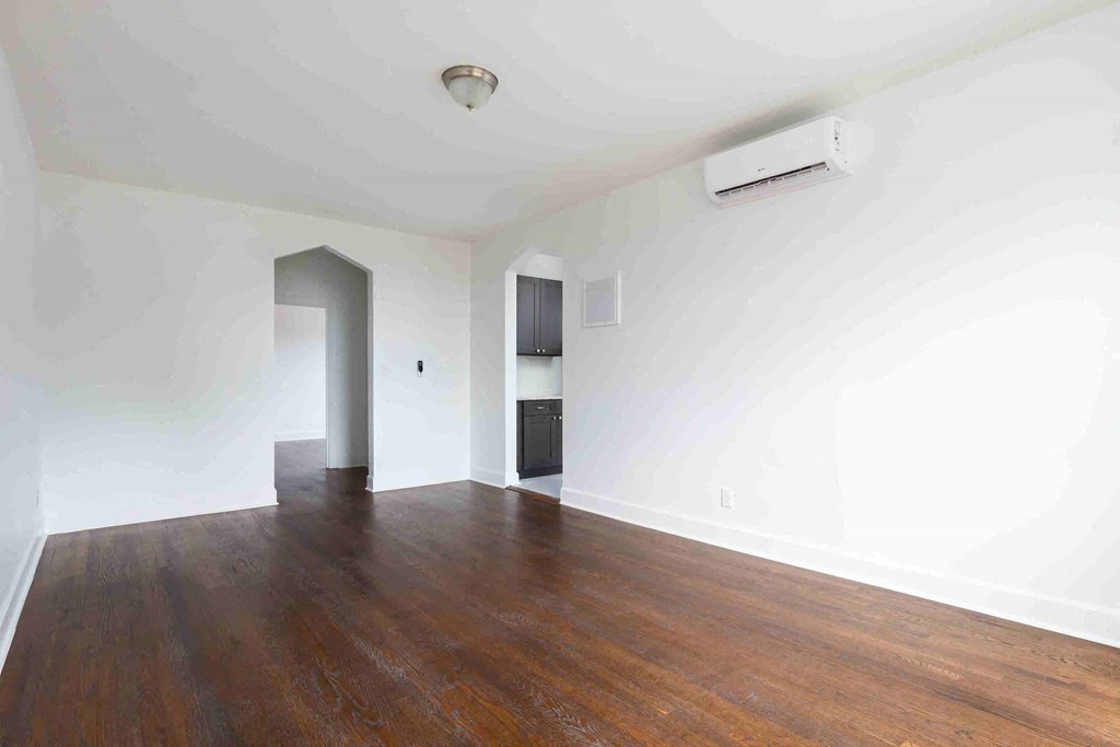 an empty living room with white walls and wood floors