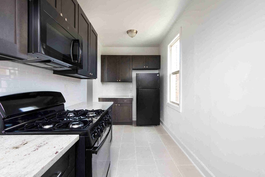 a kitchen with black appliances and a window