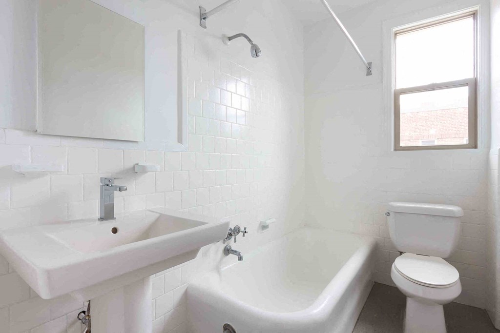 a bathroom with a sink toilet and tub and a window