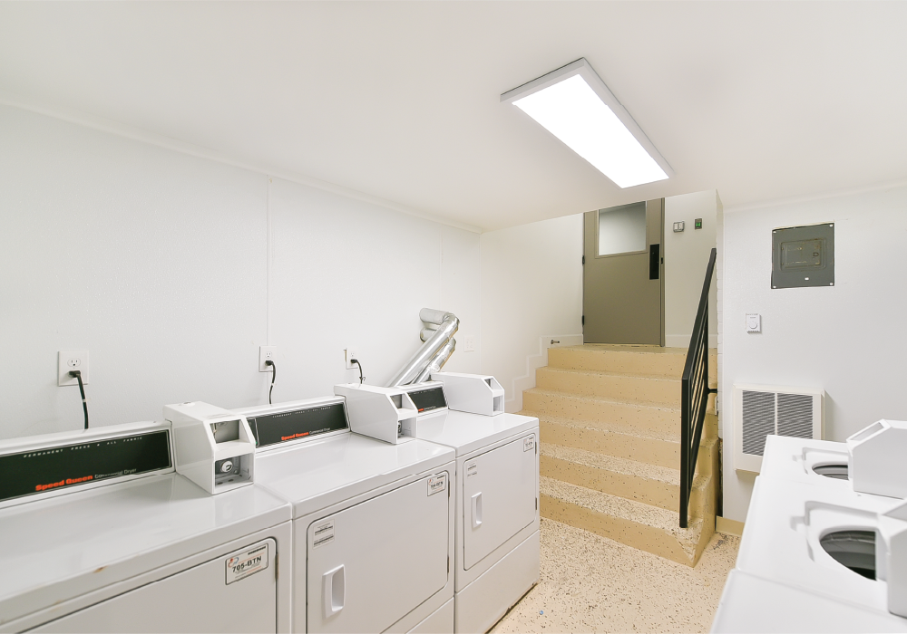 a laundry room with washers and dryers and stairs