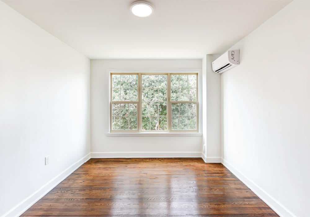 an empty room with white walls and a window