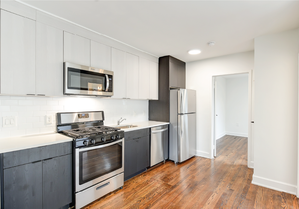 a renovated kitchen with white cabinets and stainless steel appliances