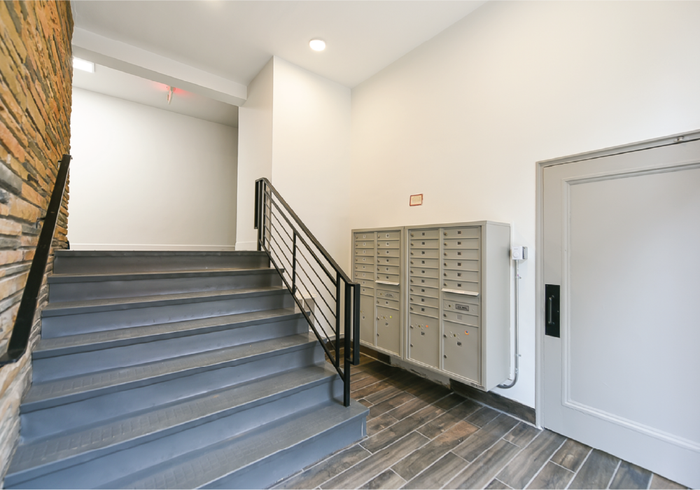 the upper lobby of a building with a staircase and a door