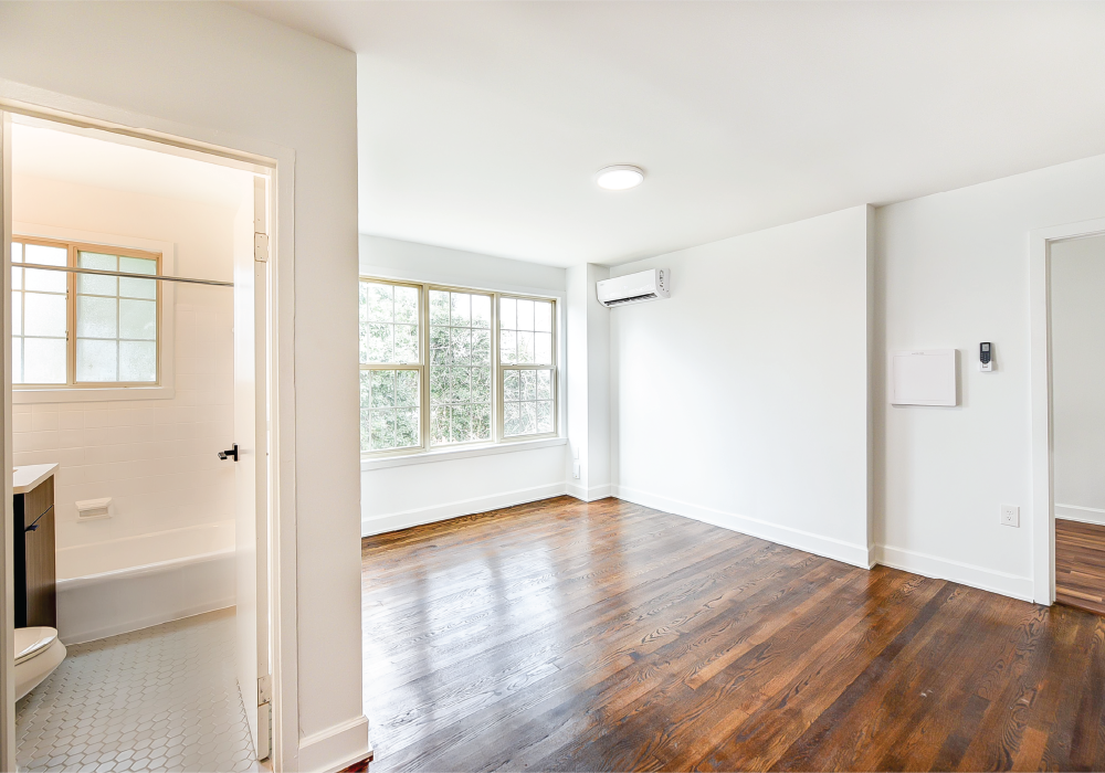 an empty living room with white walls and wood floors