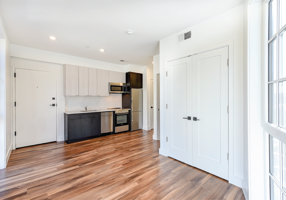 a kitchen with white doors and a wood floor
