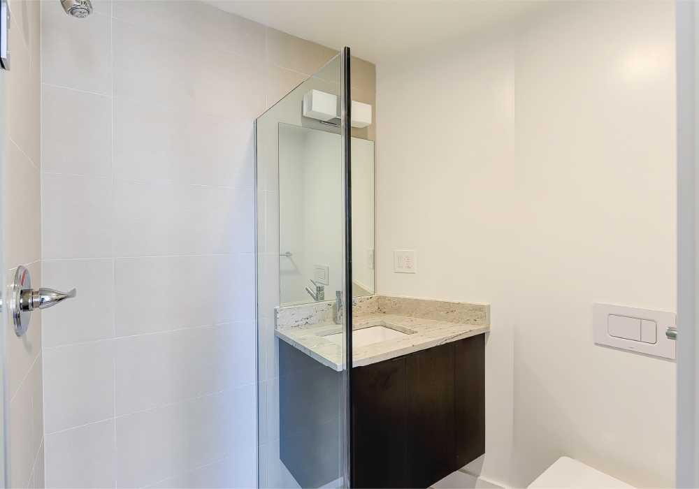 a bathroom with a shower and a sink and a mirror