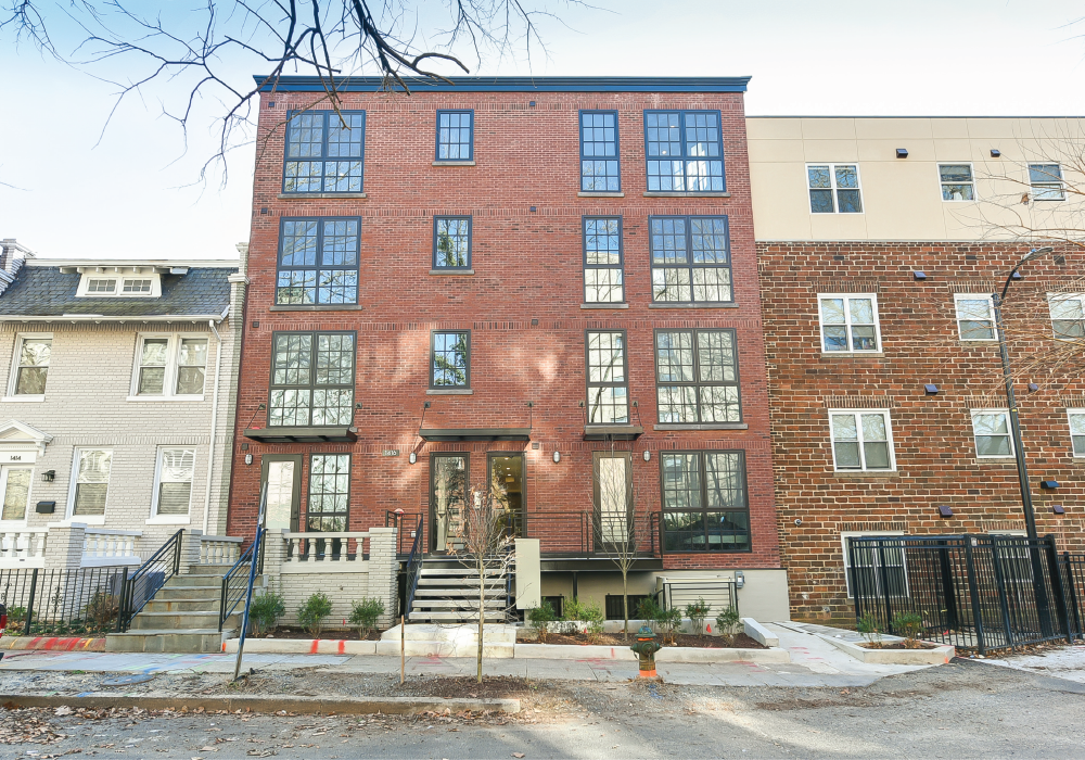 the exterior of a brick apartment building with stairs