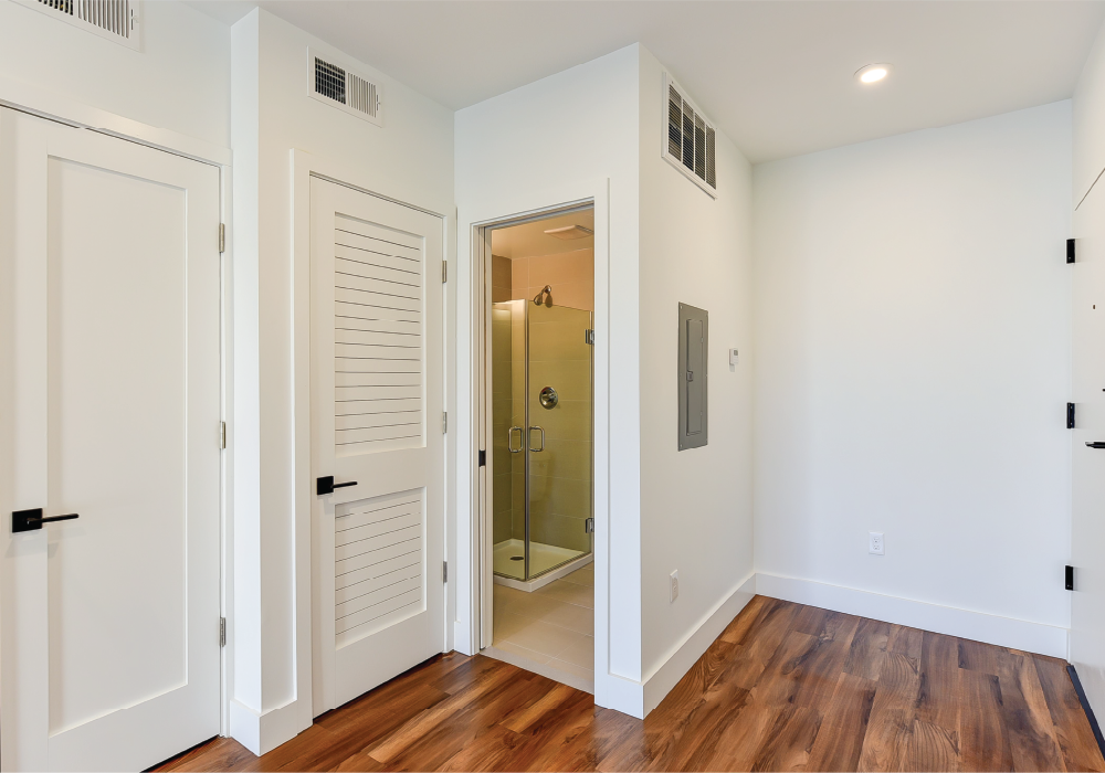 a living room with white walls and a door to a bathroom