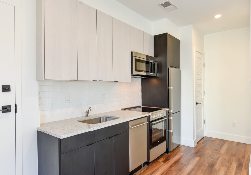 a kitchen with white cabinets and a sink and a refrigerator