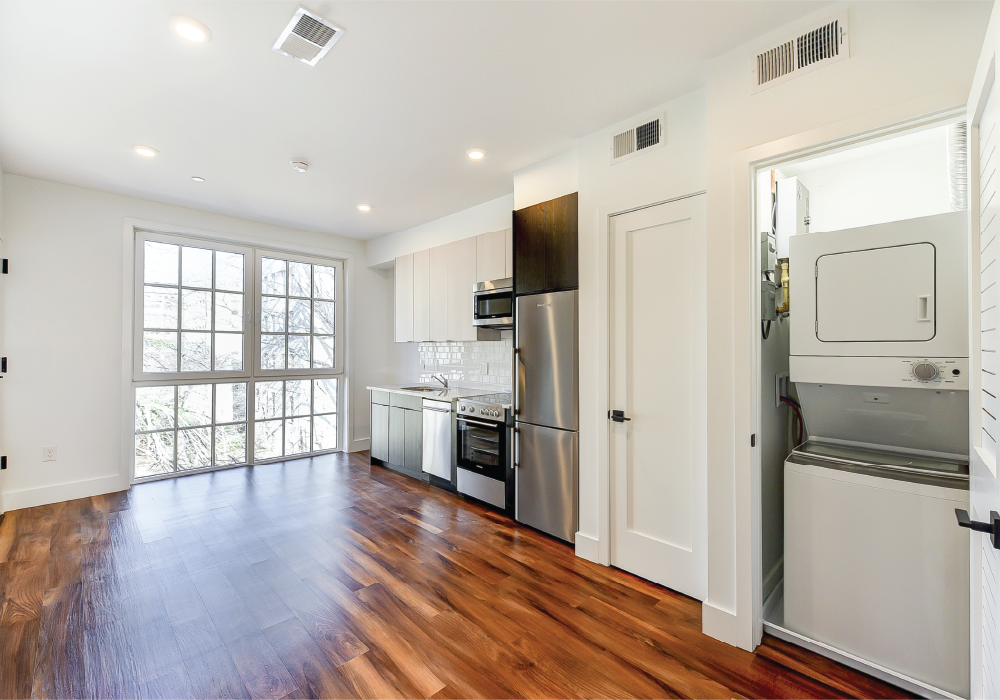 a renovated kitchen with stainless steel appliances and a hard wood floor