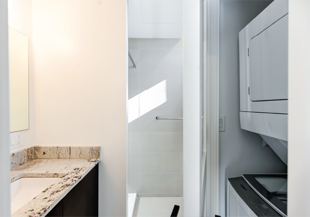 a renovated kitchen with marble counter tops and a white refrigerator