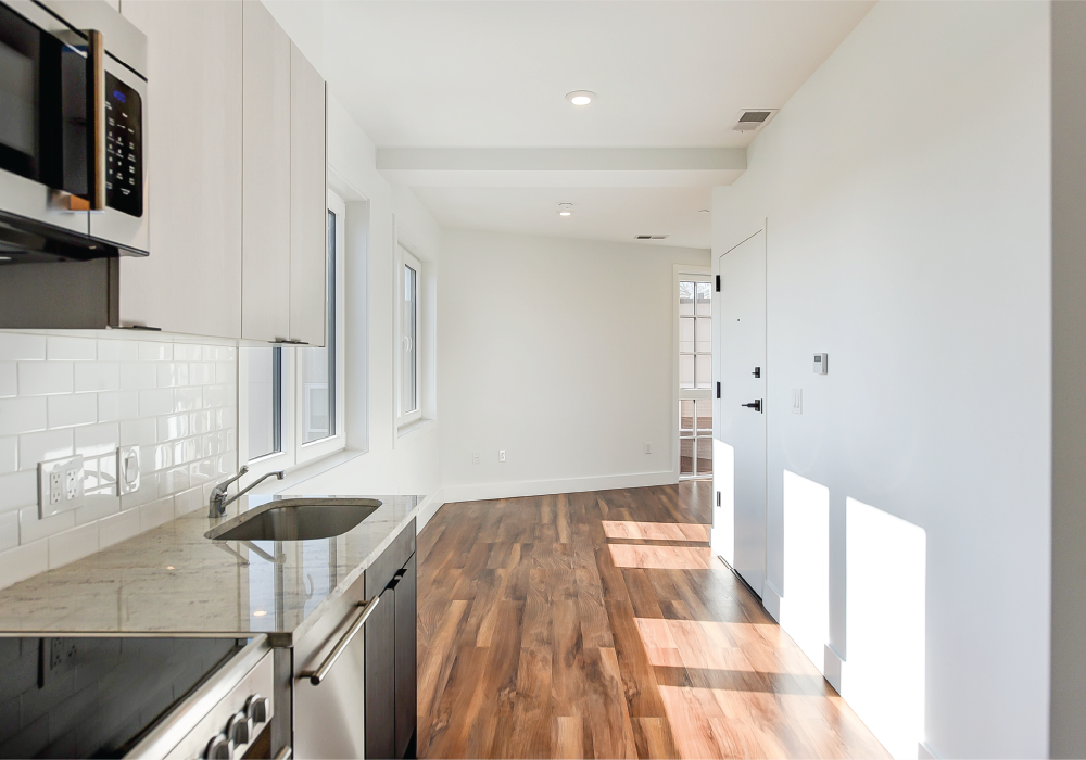 a kitchen with white cabinets and a black counter top and