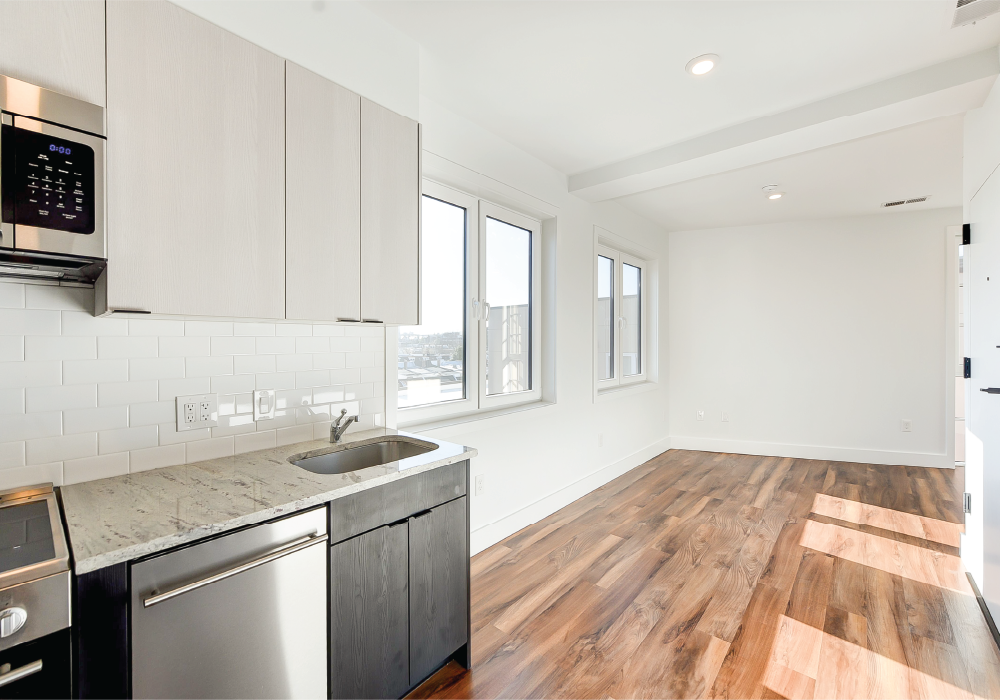 a white kitchen with a sink and a window
