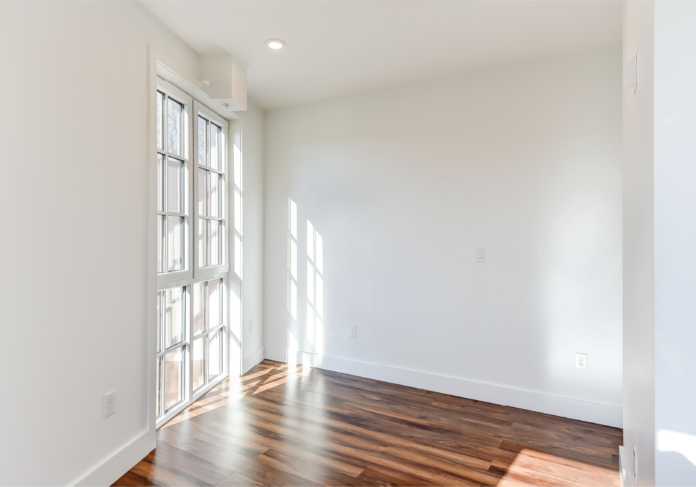 an empty living room with white walls and wood floors