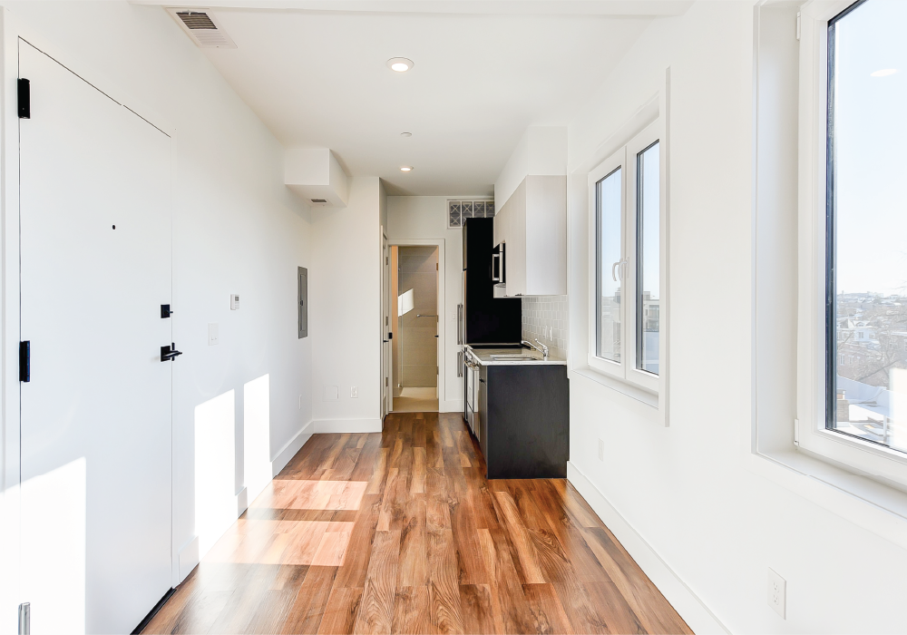 a renovated kitchen with white walls and wood floors